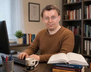 René Gäbler arbeitet an seinem Schreibtisch an wissenschaftlichen Texten und Fachbüchern.